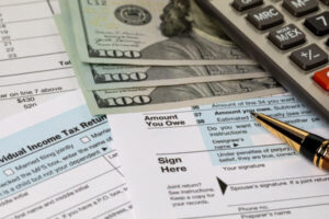 Income tax return forms with cash and pen, statute of limitations concept.