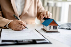 Female Real Estate Broker presenting a small model home.