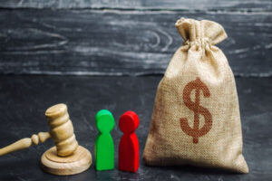 Bag of money, wooden people and the judge's hammer. The concept of property and divorce.